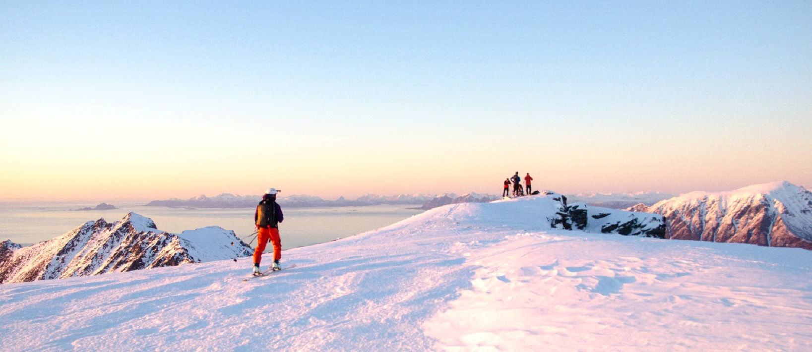 mężczyzna w górach idący do grupy znajomych ma na sobie kurtkę na skitury
