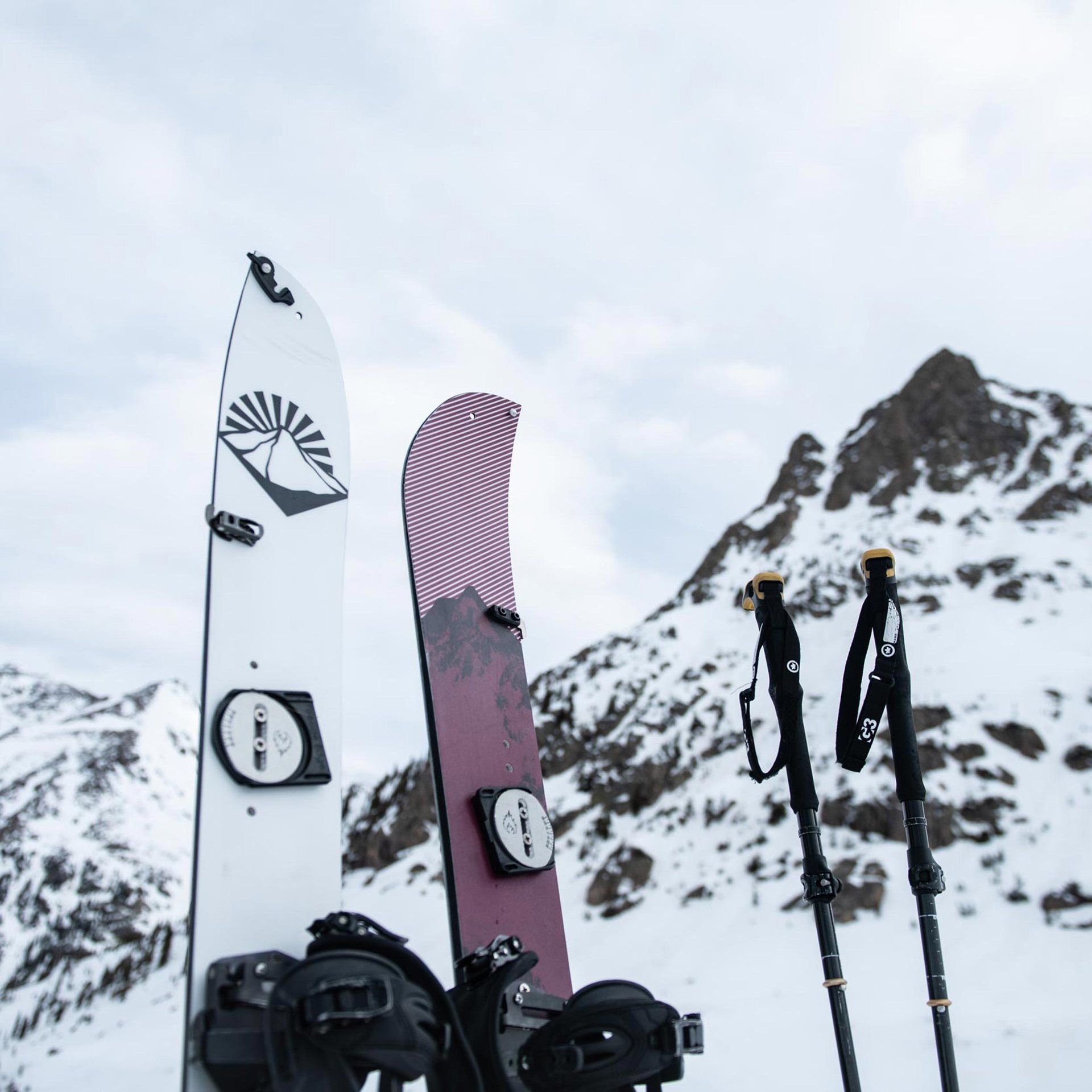 Rozłożony splitboard Weston Rise z wiązaniami na tle gór.